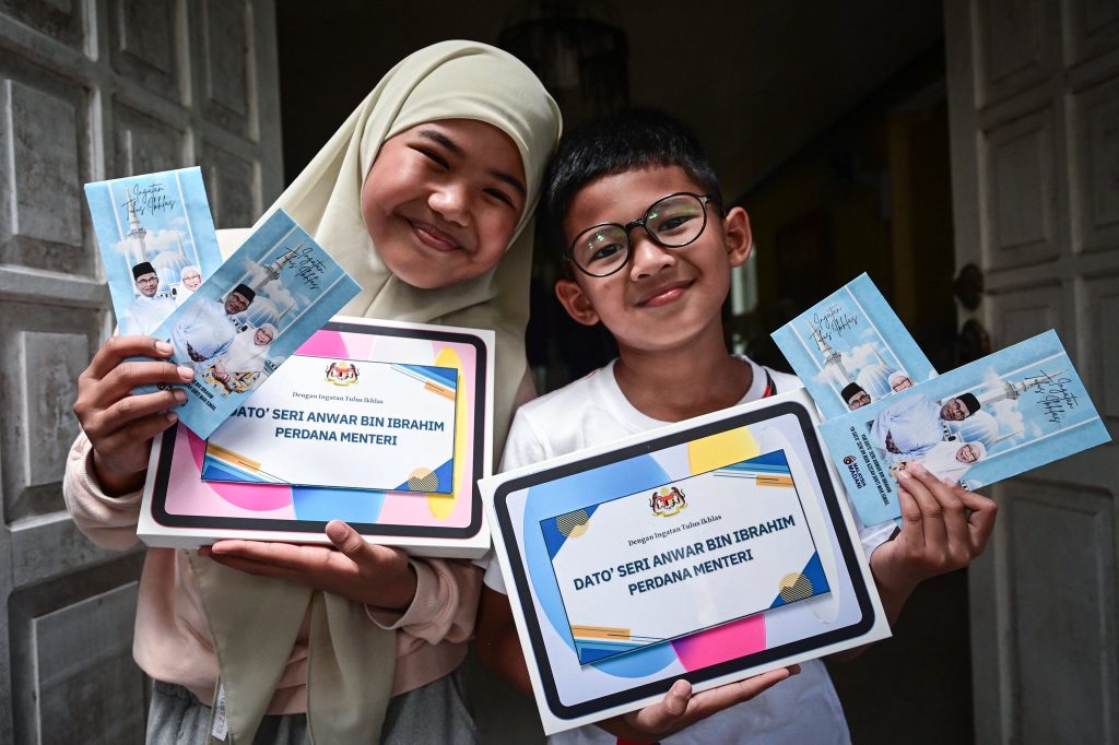 KUALA TERENGGANU -- The heartfelt gesture of two siblings giving their Hari Raya money to Prime Minister Datuk Seri Anwar Ibrahim yesterday moved the national leader, who reciprocated with a gift of his own today. Aesha Khadeeja Anuar, 10, said she and her younger brother, Uwais AlQorni, 8, never expected their spontaneous gesture of giving their Hari Raya money to the Prime Minister as he was about to board a plane at Sultan Mahmud Airport in Kuala Nerus last night, would be returned today, leaving them with a particularly special memory. “…my brother, mother (Liza Fazilah Abdul Hamid, 49) and I were on our way home after coming back from Quran lessons. When we reached a traffic light, we saw a police escort with the Prime Minister’s convoy heading towards Kuala Nerus, so I asked my mother to follow them until we reached the airport. “When we saw the Prime Minister at the airport, we quickly took out our school allowance and gave it to him. I wanted to give him Hari Raya money because it’s Syawal. I gave RM5 and my brother gave RM2,” she said after receiving donations and Hari Raya money from Anwar at their home here today. The Hari Raya money and tablets donated by Anwar were handed over by the director of the Terengganu Federal Development Department, Implementation Coordination Unit of the Prime Minister’s Department (ICU JPM), Datuk Abdul Kahar Abdul Latif. Aesha Khadeeja said she and her brother hope to visit Anwar at his Putrajaya office one day and bring him keropok lekor as a gift, adding that the Prime Minister has always been close to her heart, as he shares the same name as her father, Anuar Rashid. Earlier, Anwar shared a one‑minute 23‑second video on his Facebook page showing Aesha Khadeeja and Uwais AlQorni handing him Hari Raya money packets from outside the airport fence. In the caption, he said he was deeply moved by the children’s sincerity, calling it a humble and touching gesture. “I see this as a symbol of unity among the people, regardless of age, supporting one another as we go through the crisis we are in now. Seeing these faces, I feel a deep sense of tenderness and affection; it is our responsibility to ensure every Malaysian child is raised with love, good guidance and equal opportunities. “May Uwais and Aesha grow up to be knowledgeable, well‑mannered and bring good to their family and to the nation,” he said. Yesterday, Anwar made a one‑day visit to Terengganu, attending several events, including the launch of the National Quran Recitation and Memorisation Ceremony at the Dewan Arena Indoor Stadium in the State Sports Complex, Gong Badak, Kuala Nerus. -- BERNAMA