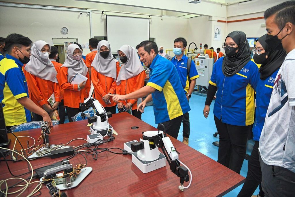 Malaysian vocational college students practising technical skills in a training workshop